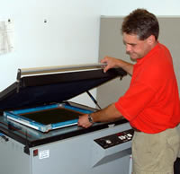 Mier Products can silk-screen your logo or graphic to your metal enclosure: Step 3, exposure unit burns image on screen.